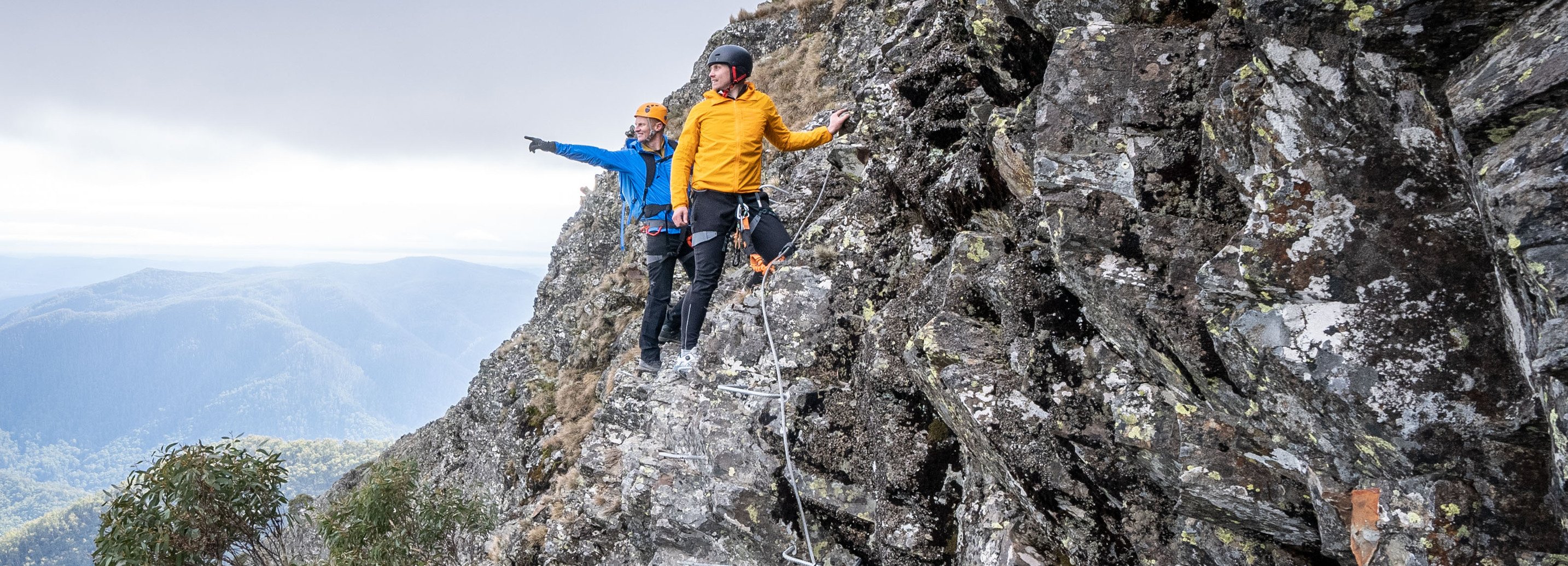A guide and climber take in the stunning view from the RockWire 'via ferrata' course across the Delatite Valley